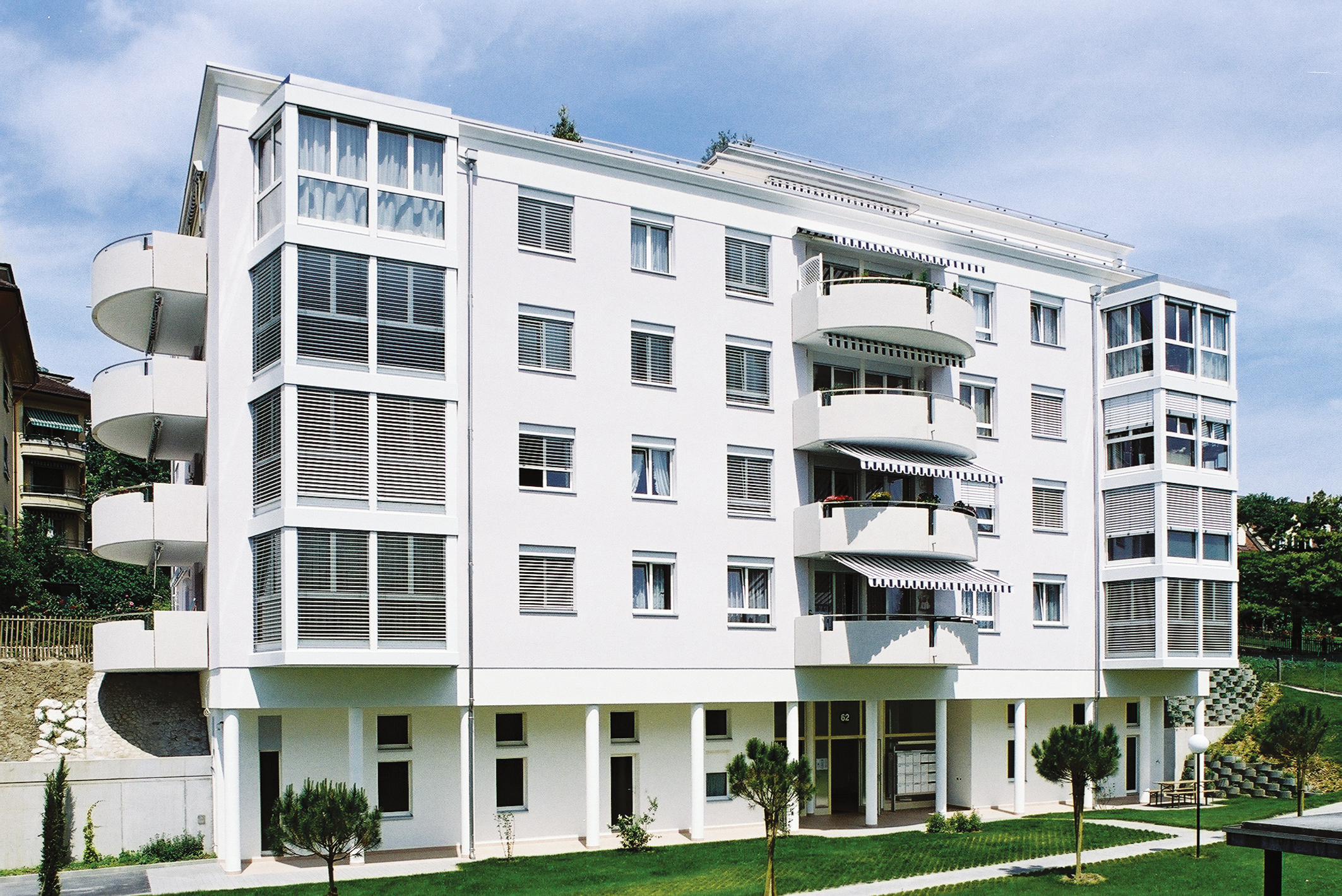 Façade blanche des Résidences Rhodanie avec ses loggias arrondies et ses stores