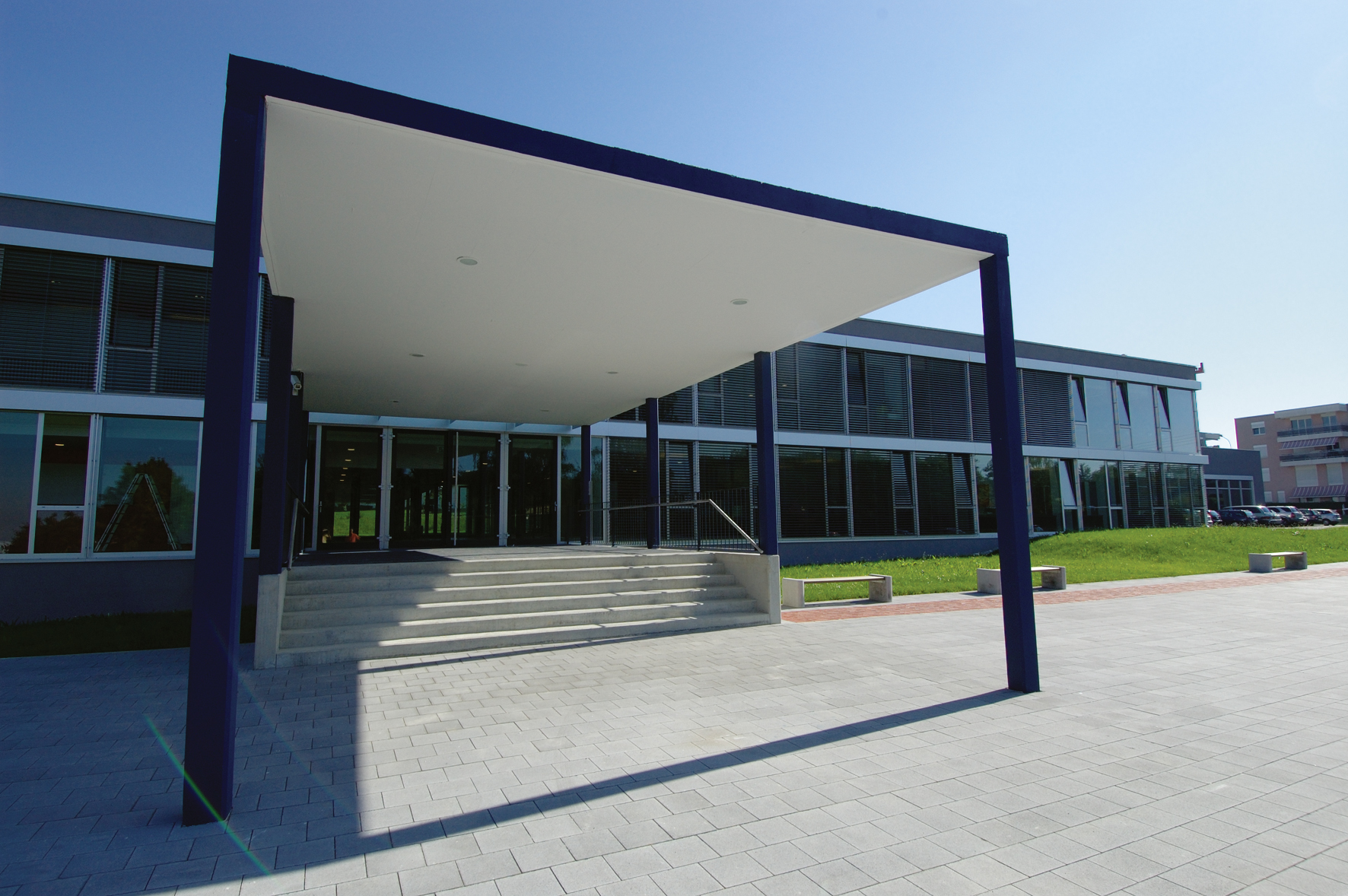 Entrée extérieure de l'International School of Lausanne encadrée d'un portique bleu foncé