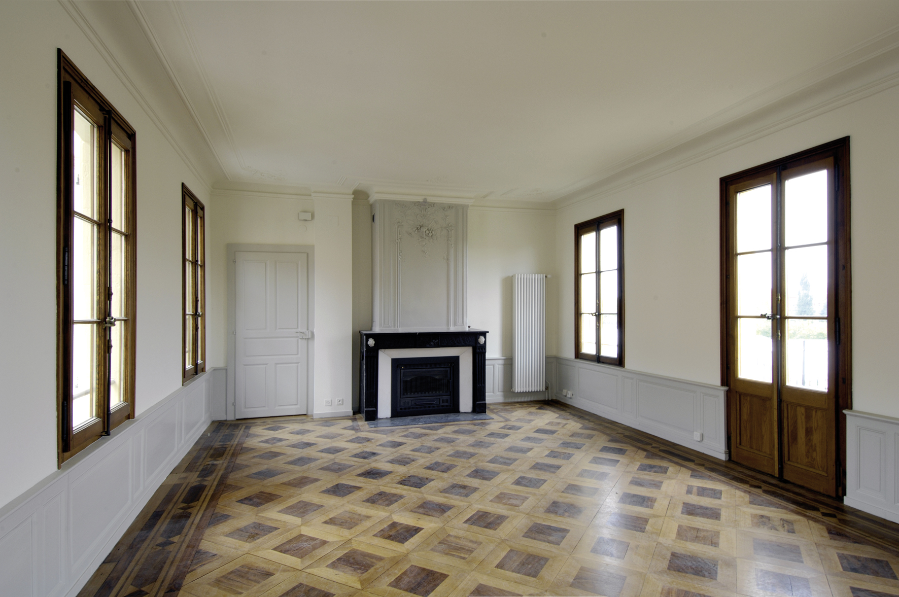 Salon d'époque de la Ferme Creux, parquet marqueté, cheminée et fenêtres à petits carreaux