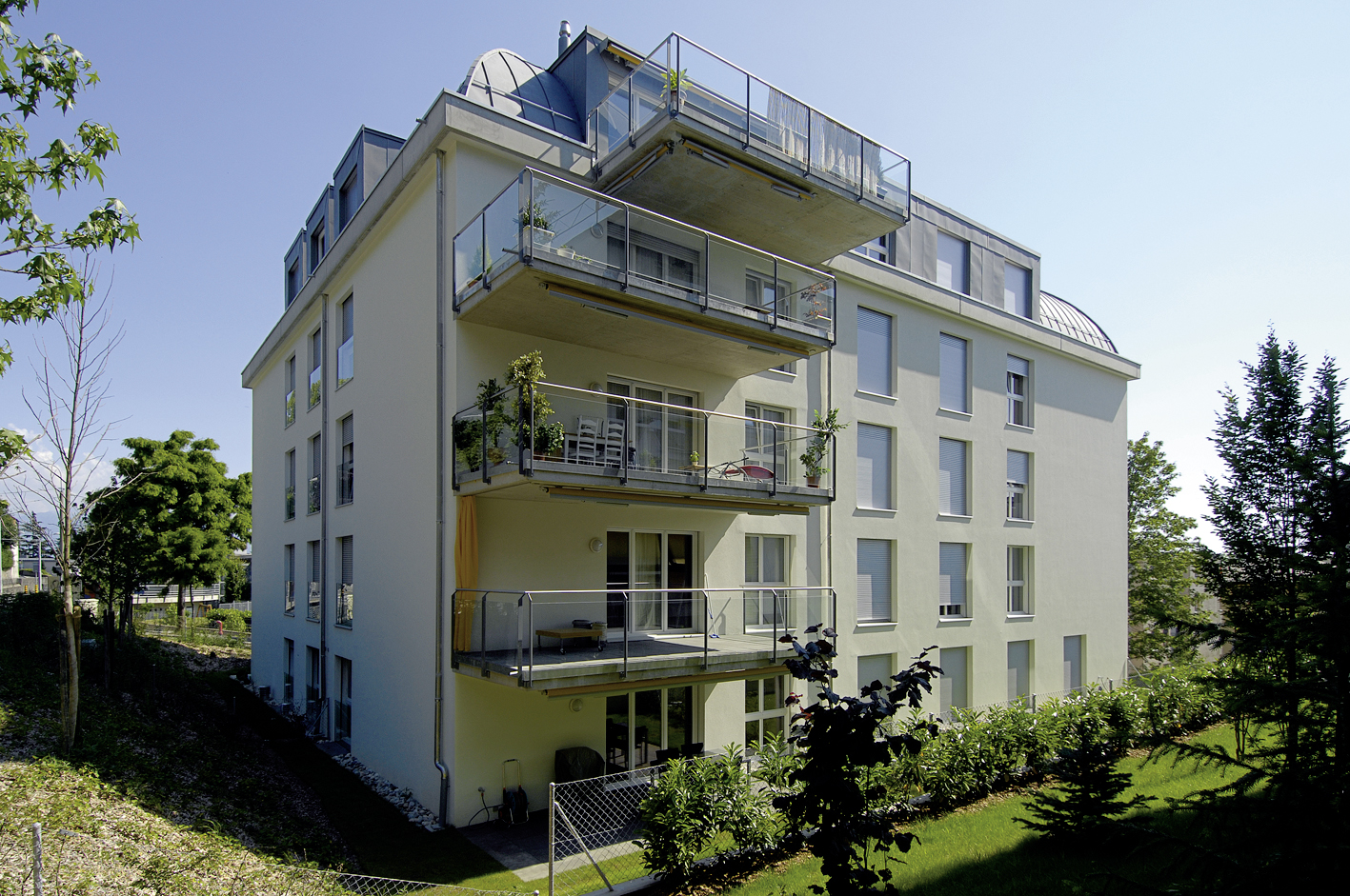 Façade claire des Balcons de Vallombreuse avec ses balcons et son attique, côté jardin