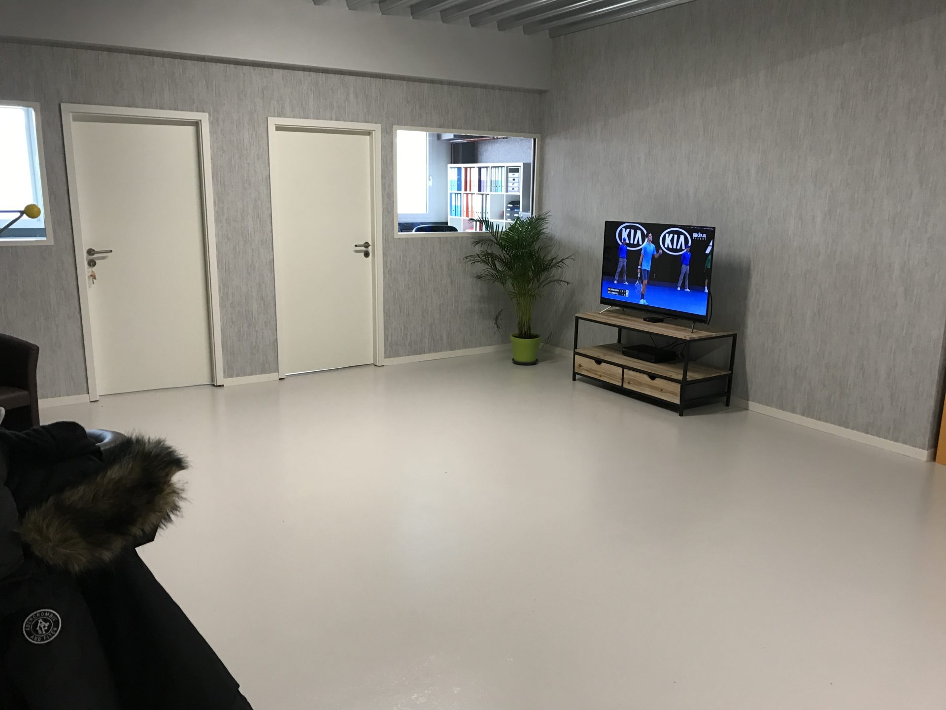 Espace de détente de l'atelier G. Pucci SA, murs à l'enduit gris et sol en résine