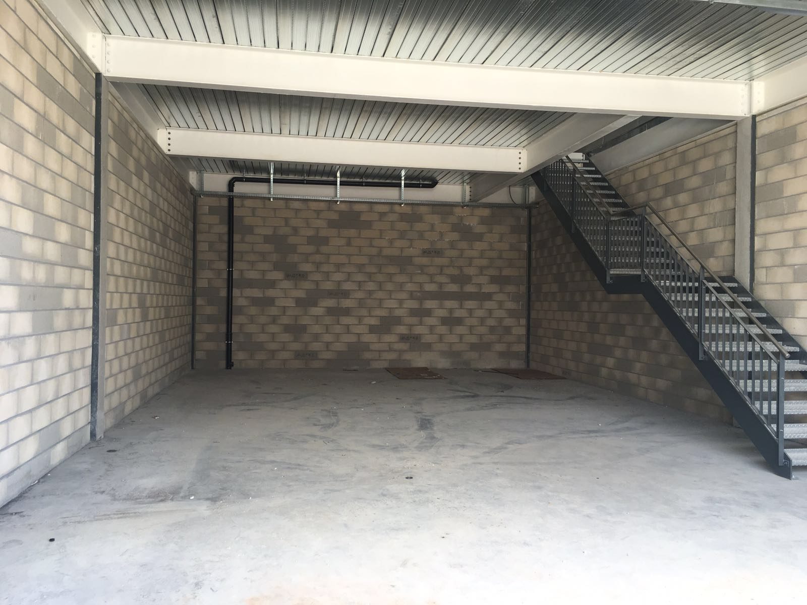 Halle de l'atelier G. Pucci SA avec son escalier métallique et son mur en briques apparentes