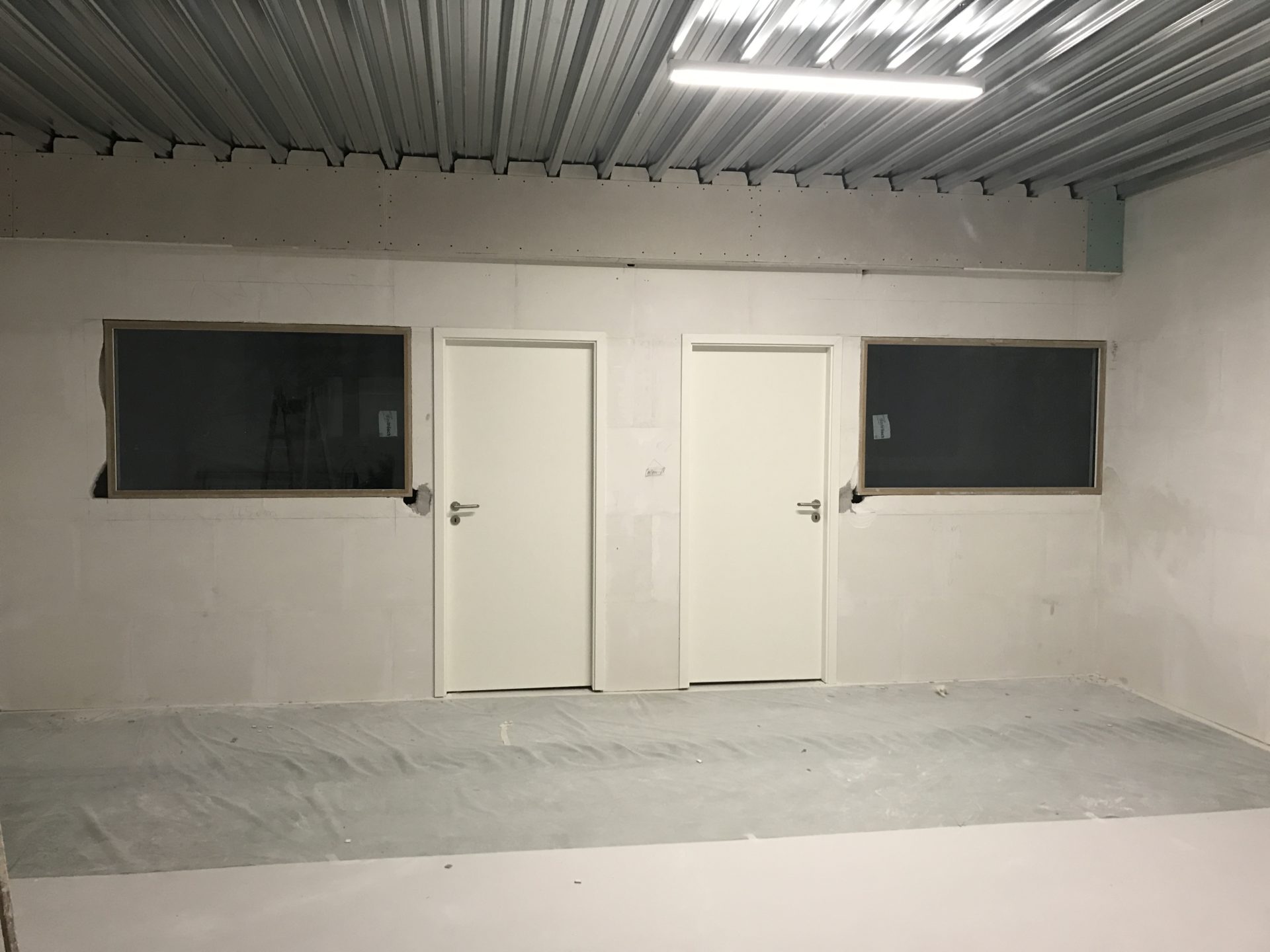 Bureaux de l'atelier G. Pucci SA avec portes blanches et cloisons vitrées