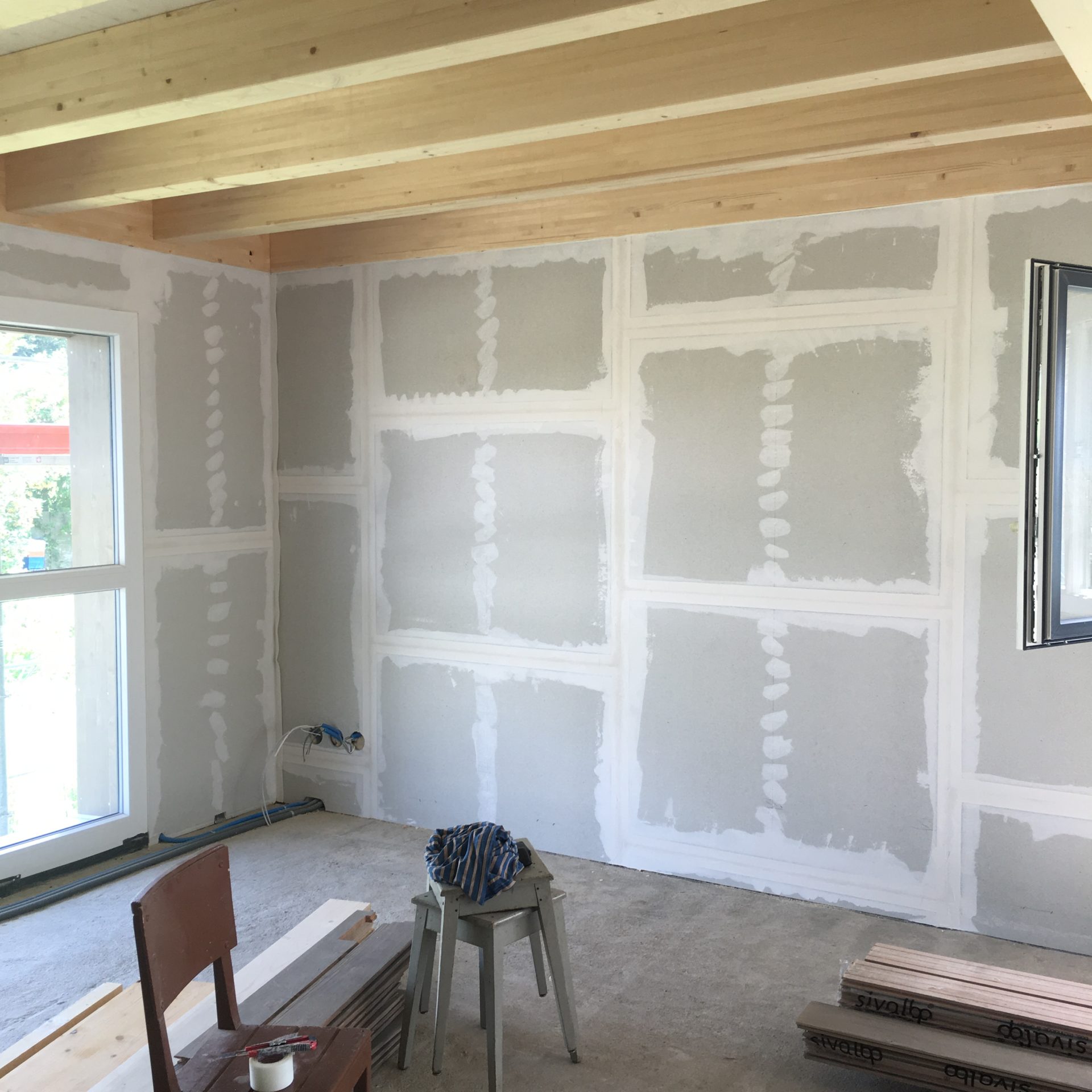 Pièce de l'ancienne ferme en cours de finition, bandes de plâtre et plafond en bois clair