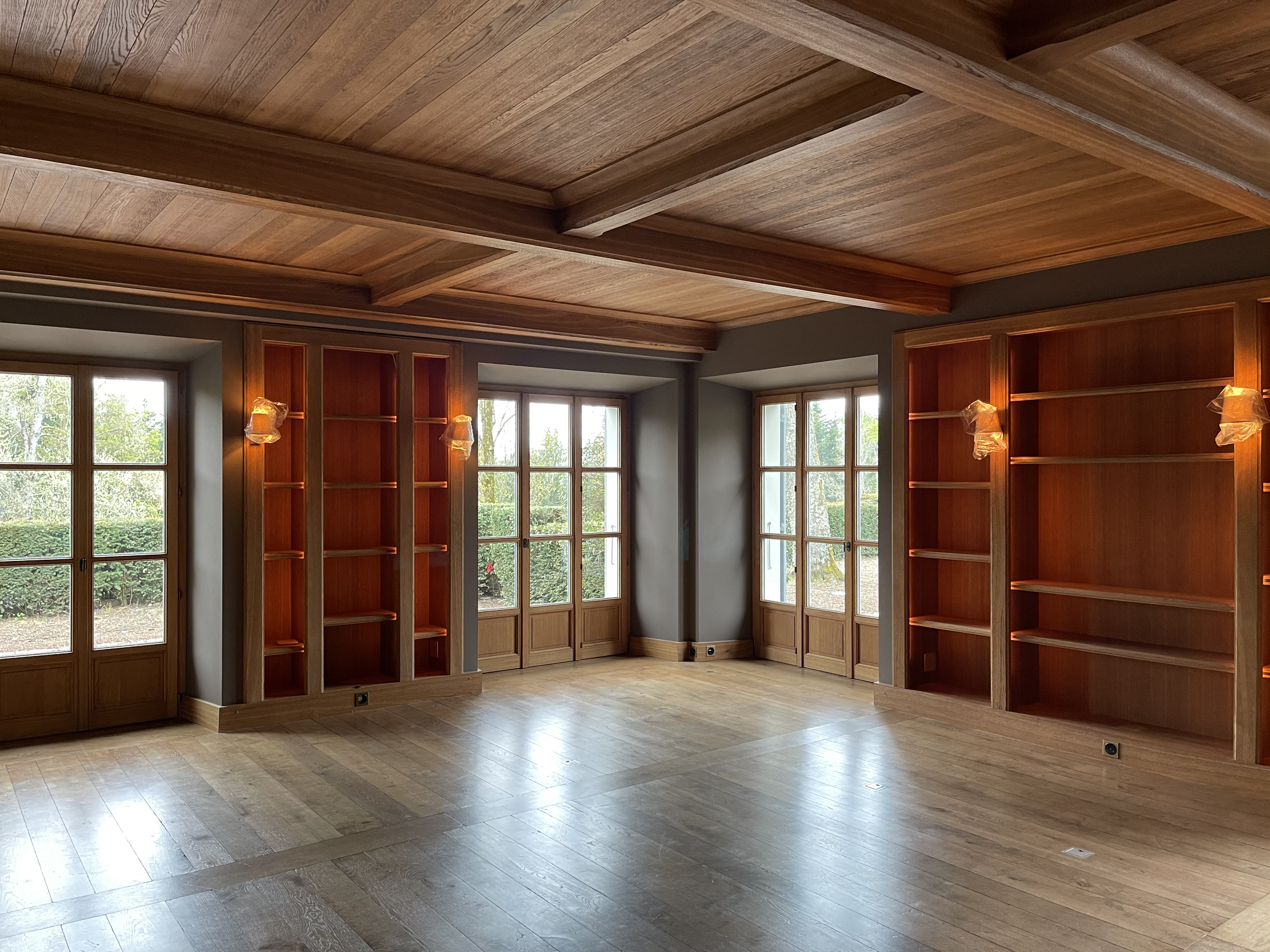 Grande pièce de la maison de maître, plafond à caissons en bois et bibliothèques d'origine