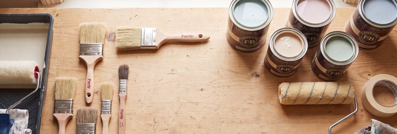 Pinceaux, rouleaux et pots de peinture sur un établi