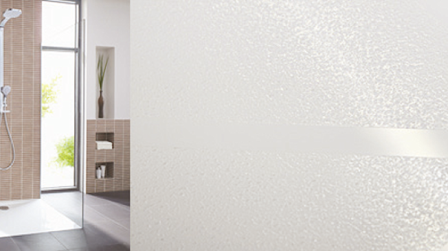 Cabine de douche carrelée et gros plan sur la texture du revêtement antidérapant GriP appliqué au sol