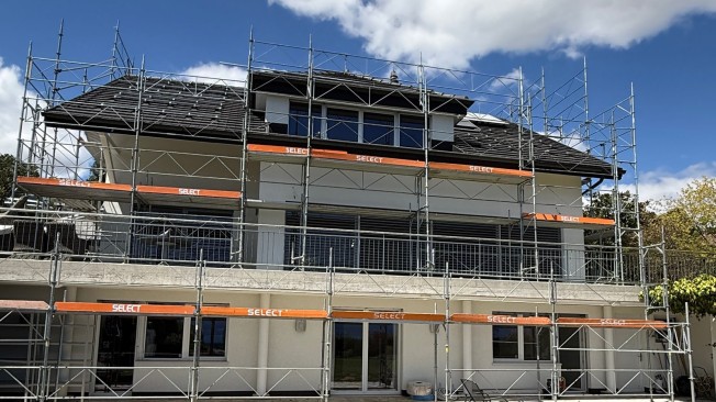 Maison individuelle entourée d'échafaudages pendant des travaux de rénovation extérieure