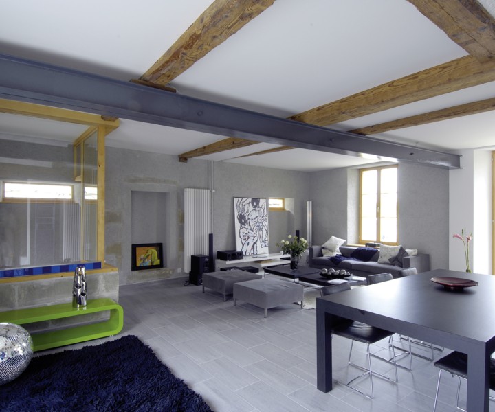 Séjour de la Ferme Creux avec poutres apparentes, cheminée et grande table à manger