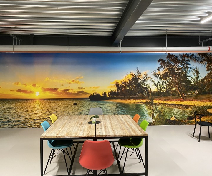 Salle de pause de l'atelier G. Pucci SA, mur imprimé d'un panorama de plage et grande table de réunion